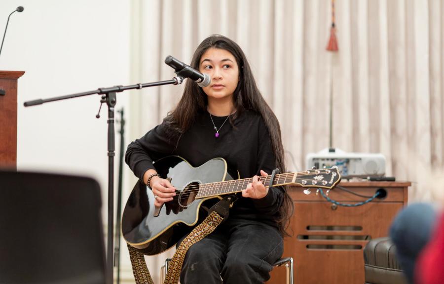 Milstein student Pareesay Afzal '24 performs an original song on guitar at the Milstein Salon.  