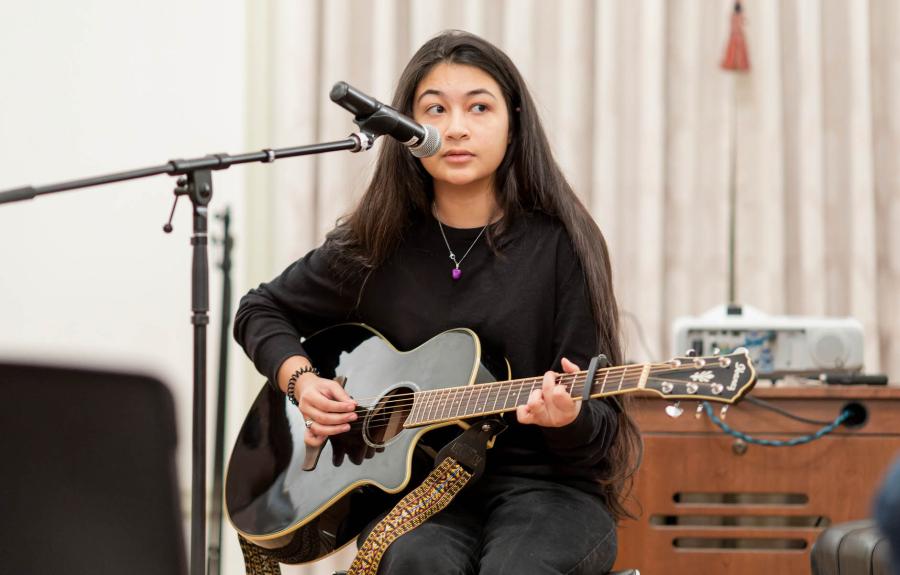 Milstein Student playing guitar in front of audience at Salon event